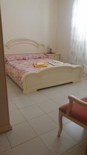 - un lit blanc dans une chambre dotée d'un sol blanc dans l'établissement Casa Solemare La Caletta, à Siniscola