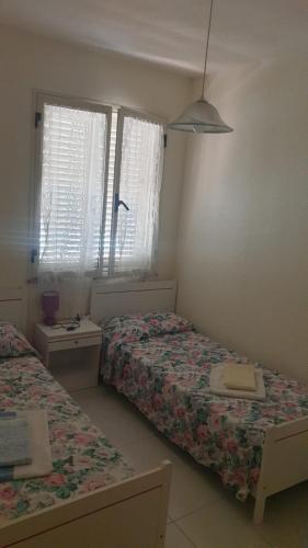 - une chambre avec 2 lits et 2 fenêtres dans l'établissement Casa Solemare La Caletta, à Siniscola