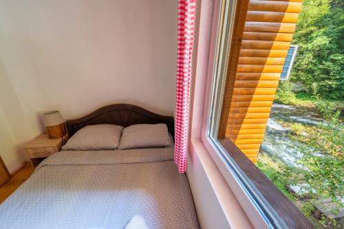 a small bed in a room with a window at Domacinstvo na kraju svijeta in Šipovo
