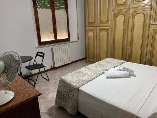 a bedroom with a bed and a table and a fan at La Sosta - intero appartamento in Ponte dʼArbia