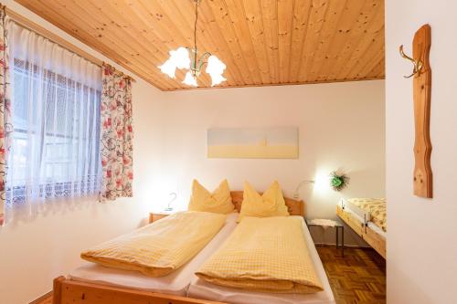 a bedroom with two beds and a window at Urlaubsbauernhof Wabnig in Moosburg