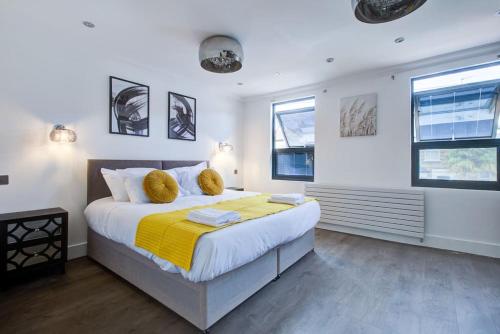 a bedroom with a large bed with a yellow blanket at Luxurious House Leyton sleep7+garden next to Stratford in London