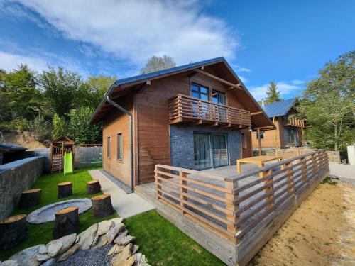 a log house with a deck and a yard at Chalet Fiona with jacuzzi in Mýto pod Ďumbierom