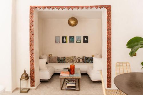 een woonkamer met een bank en een tafel bij Riad La Lumière d'Étoile in Marrakesh