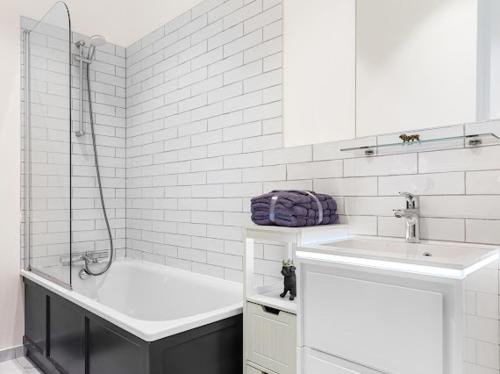 y baño blanco con lavabo y bañera. en Harley Street Luxury Snug, en Londres