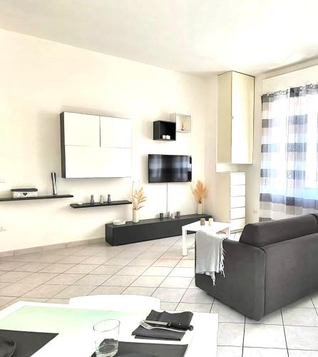 a living room with a couch and a tv at White Home Forli Centro in Forlì