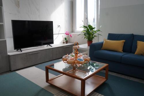 a living room with a blue couch and a tv at Welcome Milano Guest House in Milan