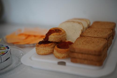 a white plate with bread and pastries on it at Welcome Milano Guest House in Milan