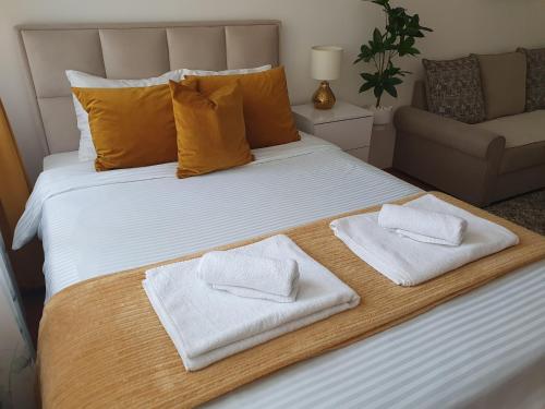 - un grand lit avec 2 serviettes blanches dans l'établissement Stan na dan Golden apartman, à Zaječar