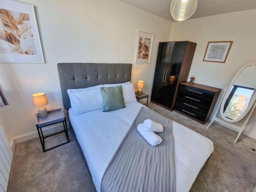 a bedroom with a large white bed with a mirror at Free Parking: Old Trafford Apartment in Manchester