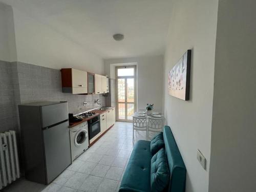 Una sala de estar con un sofá y una cocina. en Casa Gab, en Turín
