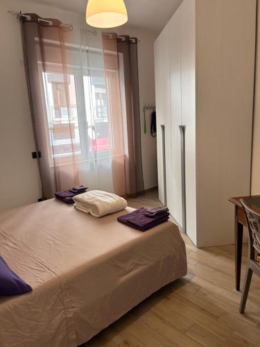 een slaapkamer met een bed, een tafel en een raam bij Gold sand in Cagliari