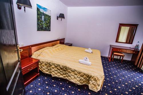 a bedroom with a bed with two white shoes on it at Casa Octavian in Suceviţa