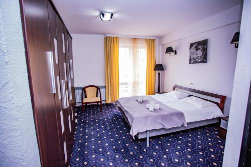 a hotel room with a bed and a table at Casa Octavian in Suceviţa