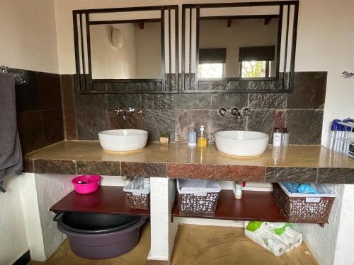 a bathroom counter with two sinks and a mirror at The Cheetah Rest in Hoedspruit