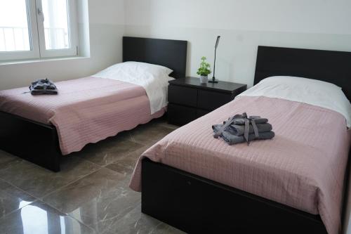 two beds in a bedroom with two bags on them at Welcome Milano Guest House in Milan