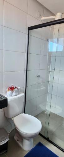 ein Badezimmer mit Toilette und Glasdusche in der Unterkunft Chaleville Maramar 402 in Luis Correia