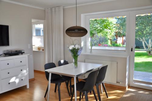 Apartment Aste في Aldrans: غرفة طعام مع طاولة مع كراسي و إناء من الزهور