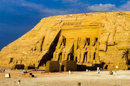 a large rock structure with people standing in front of it at Safari Abu Simbel in Abu Simbel