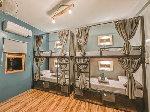 a room with two bunk beds with a mirror at Outpost Hostel - Coron in Coron