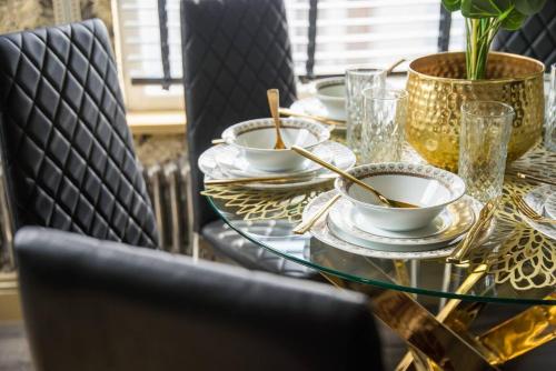 a glass table with bowls and spoons on it at Luxury Versace Sleeps10 HotTub Pool Table SkyTV in London