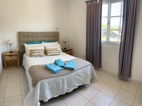 a bedroom with a bed with two blue towels on it at Departamento de La Nonna in Posadas