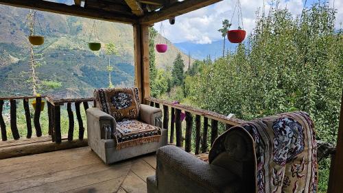 a porch with chairs and a view of the mountains at Sunils Cabin 5BHK Glass View Villa Manali in Shirir