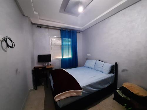 a bedroom with a bed and a desk and a window at Chambre calme et relaxante à centre ville Agadir in Agadir