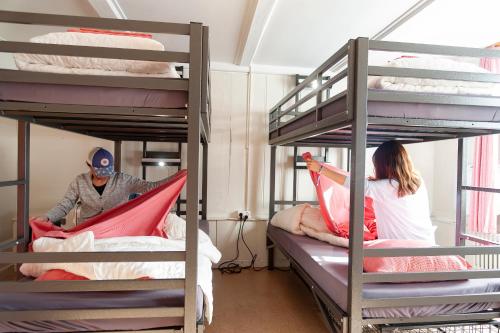 a man and a woman sitting on bunk beds at Balmers Hostel in Interlaken