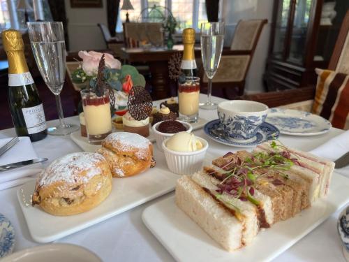 a table topped with plates of pastries and wine glasses at Castle Bromwich Hall; Sure Hotel Collection by Best Western in Birmingham