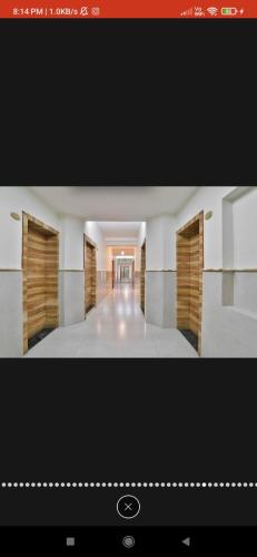 a view of a room with a hallway with wooden doors at HOTEL SURYAKANT in Rajkot