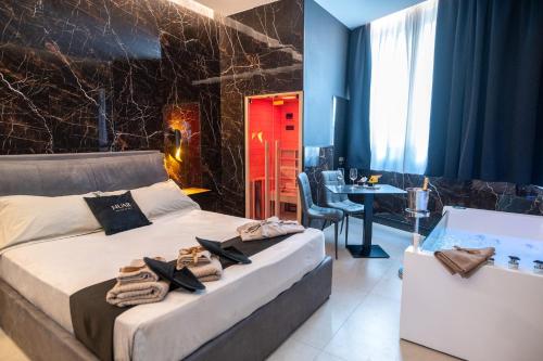 um quarto com uma cama e uma banheira com toalhas em NUAR suite&spa em Palermo