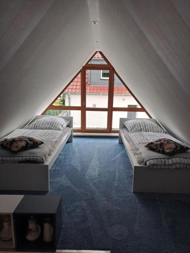 two beds in a room with a large window at Klein, aber fein in Sophienhof