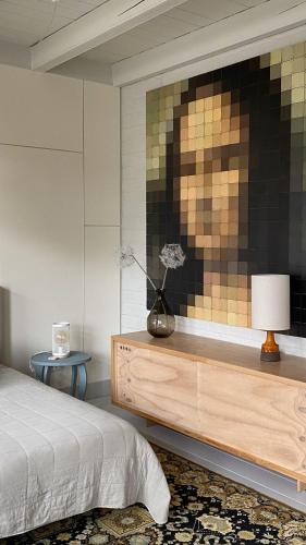 a bedroom with a bed and a painting on the wall at bij DE RODE DEUR in Meppel