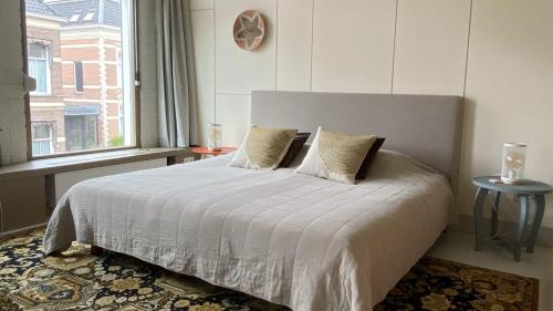 a bedroom with a large bed with a window at bij DE RODE DEUR in Meppel