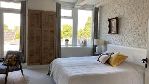 ein Schlafzimmer mit einem Bett und einem großen Fenster in der Unterkunft bij DE RODE DEUR in Meppel