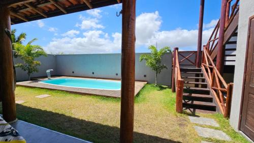 a swimming pool in a yard with a staircase next to a house at Villa Recanto do Mar - Icaraizinho de Amontada in Amontada