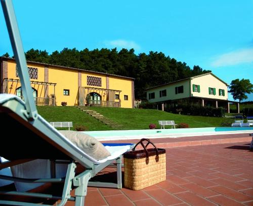 uma cadeira de relva ao lado de uma piscina em Agriturismo La Burraia em Gambassi Terme