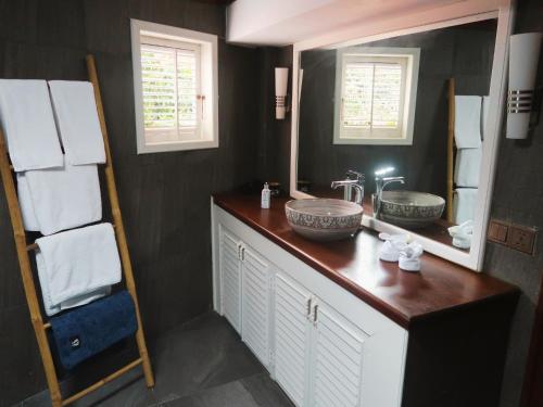 a bathroom with two sinks and a large mirror at Devi Kampot Resort at Phum Kampot in Kampot