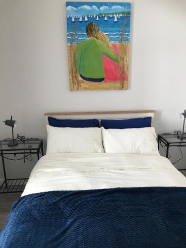 a bedroom with a bed with a painting on the wall at Brigid M’s Farm House in Killashandra