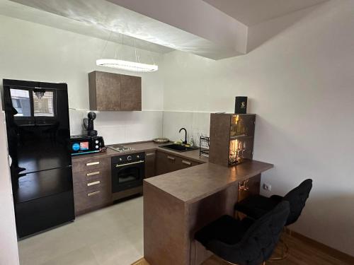 Una cocina con un refrigerador negro y una encimera. en Royal Casa, en Skopje