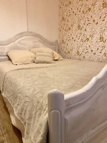 - une chambre avec un lit blanc et une tête de lit blanche dans l'établissement Nuit au calme, en pleine nature, à Bagneux