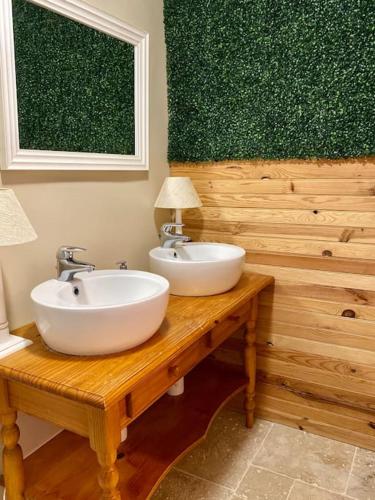 - une salle de bains avec deux lavabos sur une table en bois dans l'établissement Nuit au calme, en pleine nature, à Bagneux