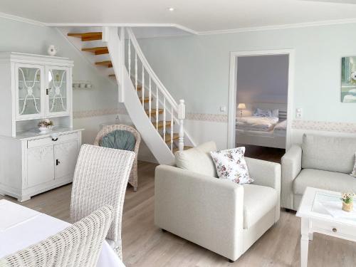ein Wohnzimmer mit einer Treppe, einem Stuhl und einem Sofa in der Unterkunft Haus Midsommer in Timmendorfer Strand