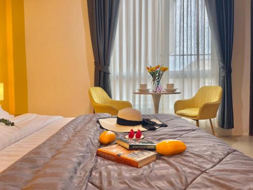 a bedroom with a bed with a hat and oranges at Studio room in Mango House in Phuket Town