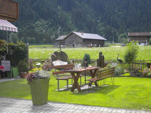 una mesa de picnic y sillas en un patio con un campo en Haus Waidmannsheil, en Mayrhofen
