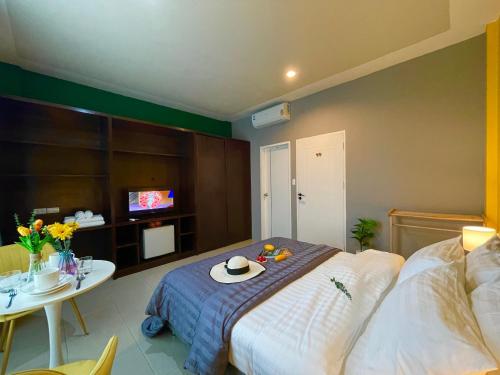 a bedroom with a bed and a table with a hat on it at Studio room in Mango House in Phuket Town