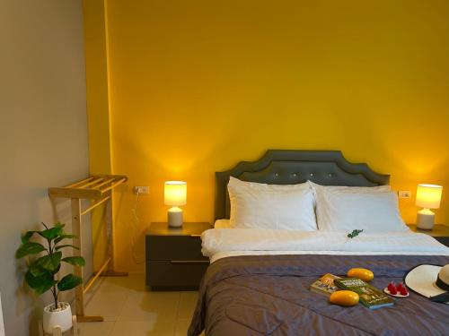 a bedroom with a bed with a yellow wall at Studio room in Mango House in Phuket Town