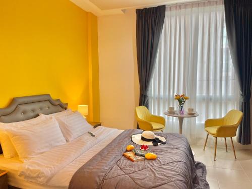 a bedroom with a bed with yellow walls and a window at Studio room in Mango House in Phuket Town