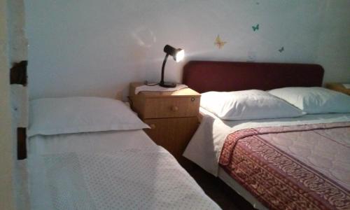 een slaapkamer met 2 bedden en een lamp op een nachtkastje bij Apartment Gabric in Rab